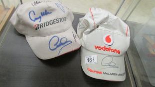 A Vodaphone McLaren Mercedes and Bridgstone caps with F1 racing signatures including Lewis Hamilton,