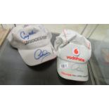 A Vodaphone McLaren Mercedes and Bridgstone caps with F1 racing signatures including Lewis Hamilton,