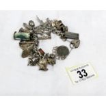 A vintage silver charm bracelet with 25 charms including some opening,