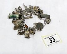 A vintage silver charm bracelet with 25 charms including some opening,