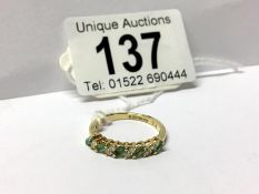 An emerald diamond band ring in 18ct gold,