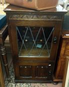 An oak music cabinet with leaded glass front