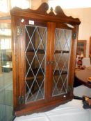 An oak wall cabinet with leaded glass doors