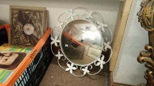 A round mirror with white floral surround