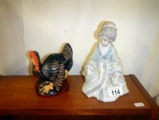 A turkey figurine money box and a Geisha figurine