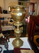 A tall brass planter