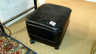 A small back leather pouffe on wheels