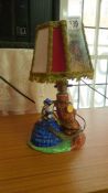 A figural lamp featuring a Lady sitting by a tree