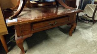 A heavy mahogony coffee table with drawer