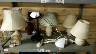 A shelf of 2 desk lamps and table lamps