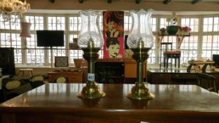 A pair of brass candlesticks with fluted glass shades