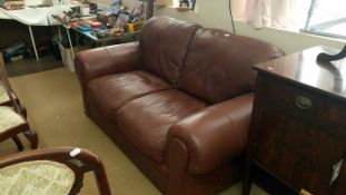 A 2 seater brown leather settee