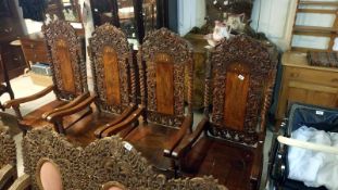 A set of 4 heavily carved teak chairs with brass inlay