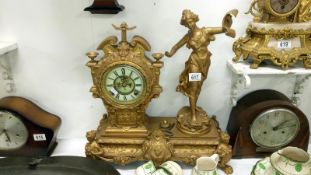 A gilded mantel clock surmounted figure