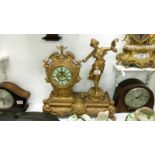 A gilded mantel clock surmounted figure