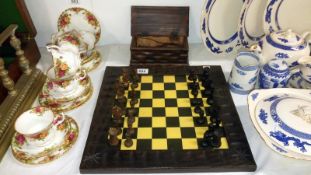 A wooden chess set in box and with board