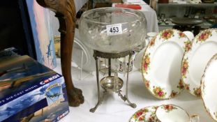 An etched glass bowl on metal stand