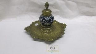 A brass and blue and white pottery ink well