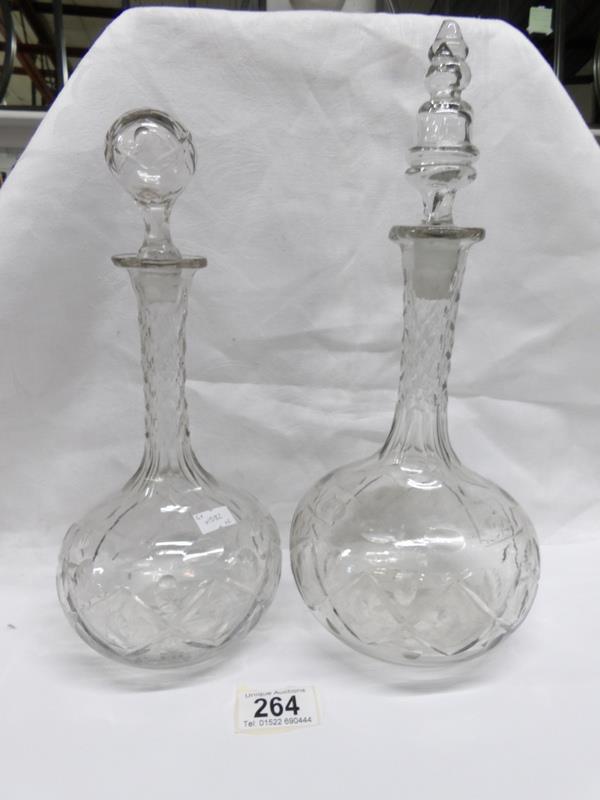 A pair of cut glass decanters (odd stoppers)