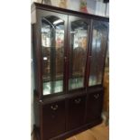 A modern dark wood stained display cabinet with cut glass doors and mirror back