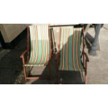 A pair of vintage hard wood deck chairs with arms