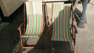 A pair of vintage hard wood deck chairs with arms