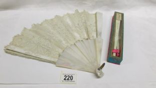 A beautiful early 20th century silk and mother of pearl fan embroidered with flowers and an a/f