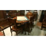 An oval dining table and 6 chairs with brass inlay