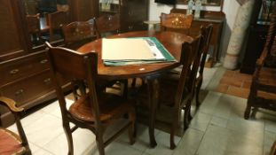 An oval dining table and 6 chairs with brass inlay
