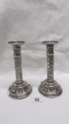 A pair of ornate Indian silver candlesticks