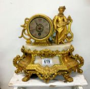 A gilt mantel clock surmounted figure