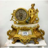 A gilt mantel clock surmounted figure