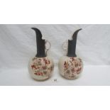 A pair of 19th century hand painted porcelain ewers