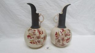 A pair of 19th century hand painted porcelain ewers