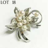 A cultured pearl brooch set with eight pearls in silver fashioned as a flower spray