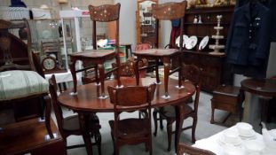 A darkwood stained dining table and chairs with brass inlay