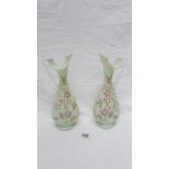 A pair of 19th century hand painted glass ewers