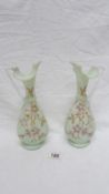 A pair of 19th century hand painted glass ewers