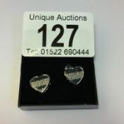 A pair of black and white diamond heart shaped gold earrings