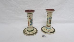 A pair of Torquay motto ware candlesticks