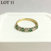 An emerald and diamond band ring set with four emeralds and three diamonds in 18st gold,