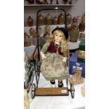 A vintage dolls pushchair and a porcelain doll