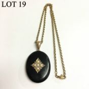 A Victorian onyx pendant set with seven seed pearls and split pearls with locket back and set in