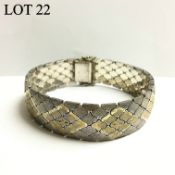 A silver bracelet with gold inlay in a diamond shape formation, approximately 44.