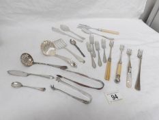 A mixed lot cutlery including sifter spoons, pickle forks, sugar tongs etc