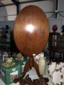 An oval mahogany tip top tripod table