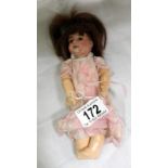 A small 19th century doll with porcelain head and composition body