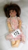 A small 19th century doll with porcelain head and composition body