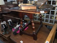 A 1930s small oak rotating top drop leaf table