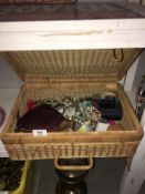 A wicker basket containing costume jewellery